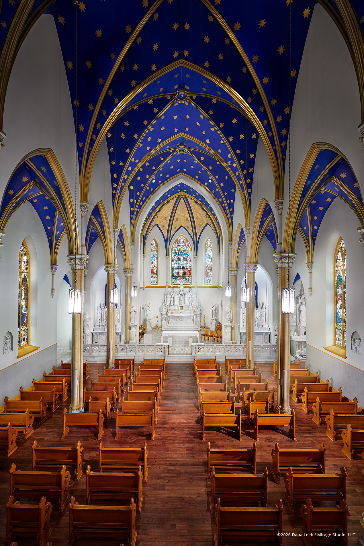 Franciscan Health Lafayette Central’s St. Francis Chapel, with its restored royal‑blue star ceiling, white marble altar, and rows of warm wood pews.